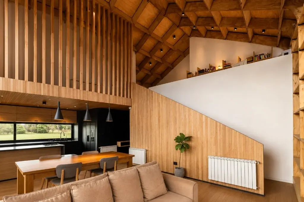 Surface Construcciones — Casa Nórdica (Trevelin, Patagonia), amplia doble altura con entramado artesanal de madera en cielorraso y estar integrado