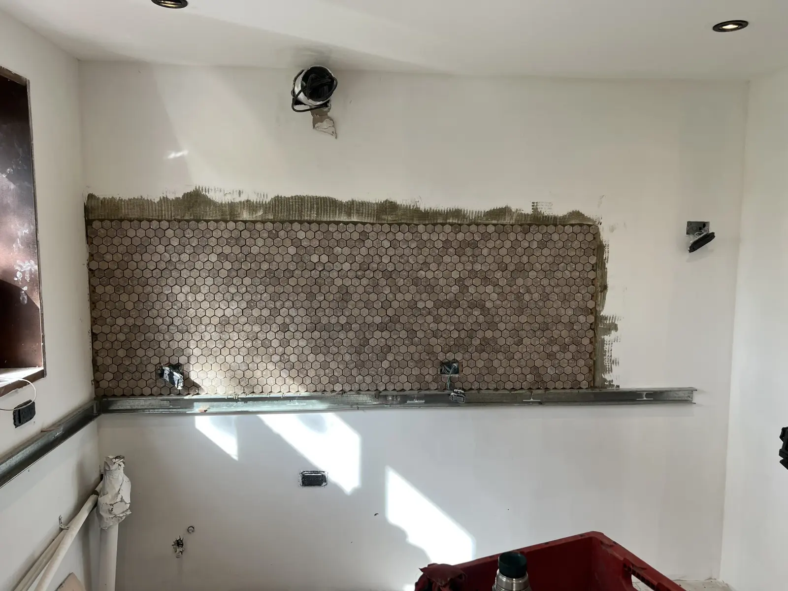 Surface Construcciones — Casa Huésped en Trevelin, colocación artesanal de mosaico hexagonal en pared de cocina