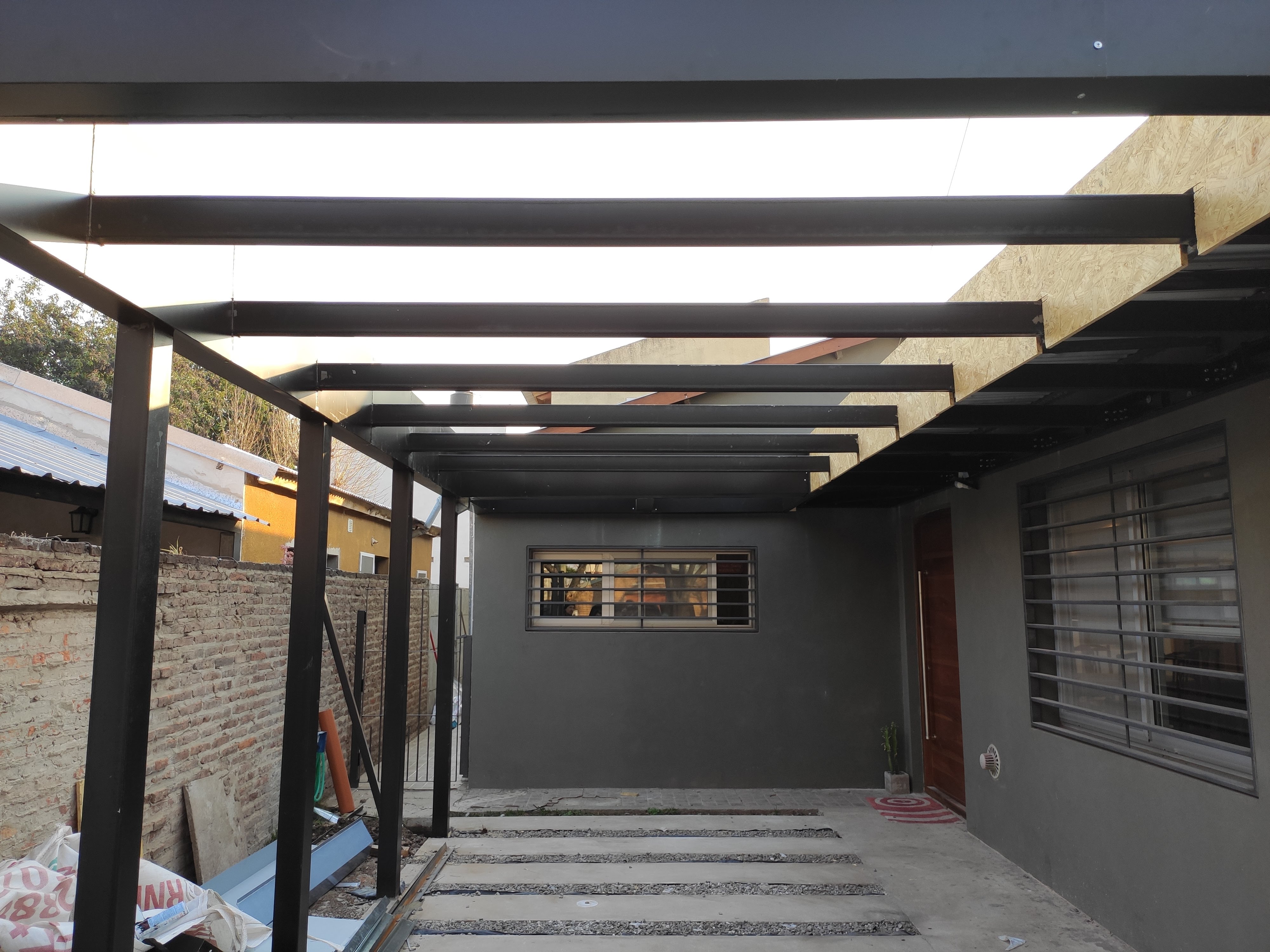 Surface Construcciones — Flipping Galería, perspectiva de la pérgola metálica y muro exterior