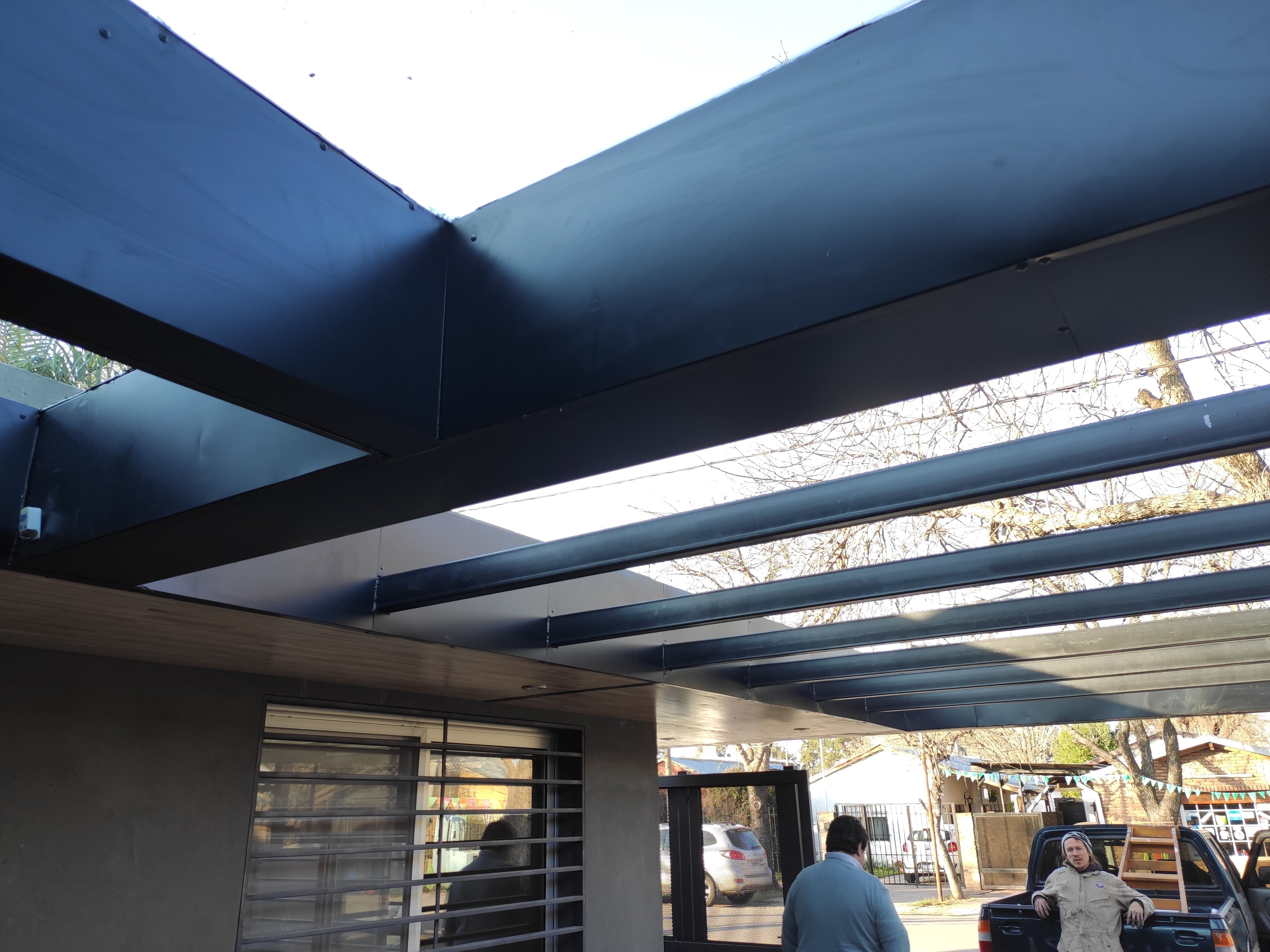 Surface Construcciones — Flipping Galería, fachada renovada con revestimiento oscuro y carpinterías