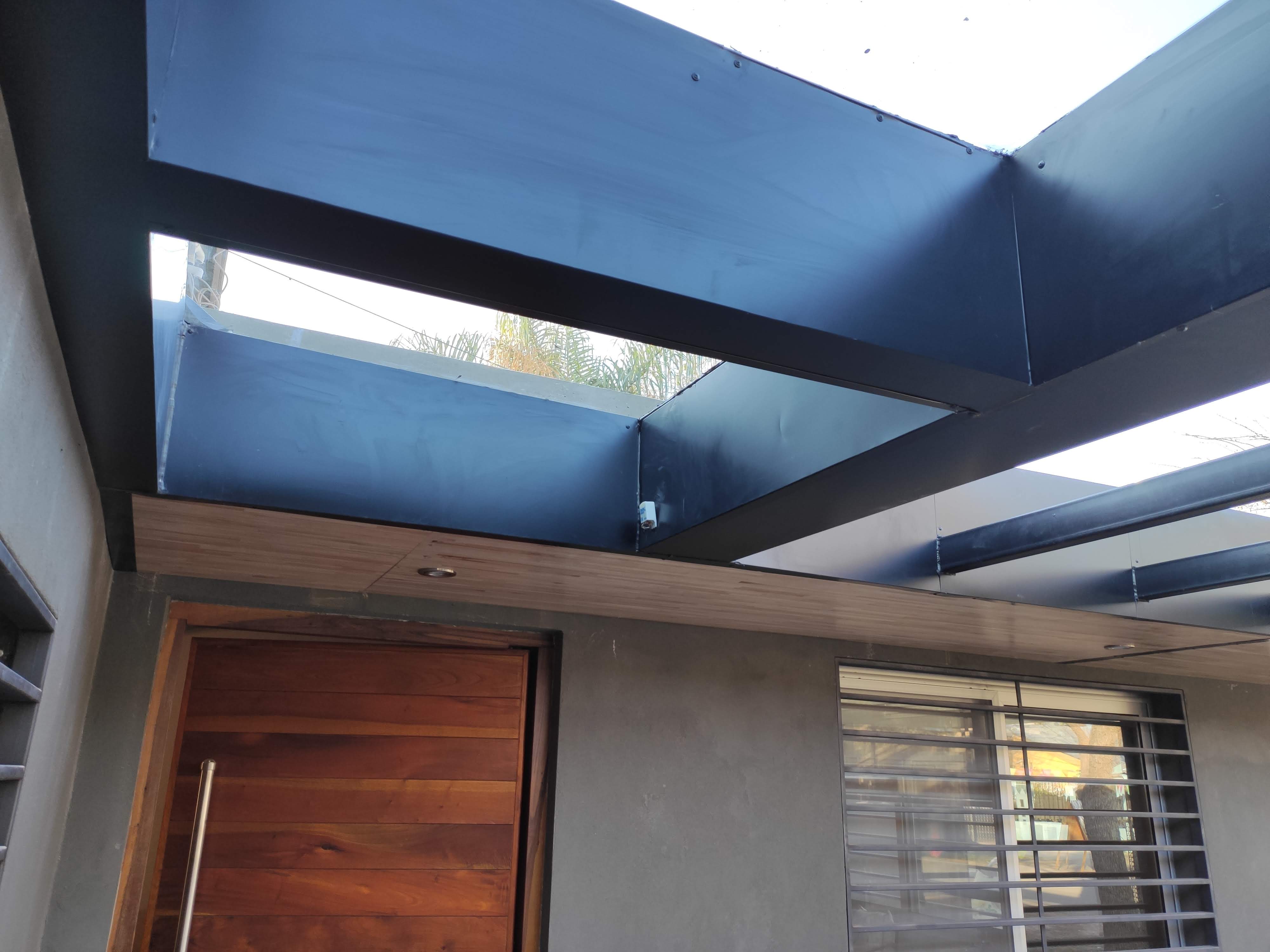 Surface Construcciones — Flipping Galería, portón de reja desplegada y frente de la vivienda acondicionado