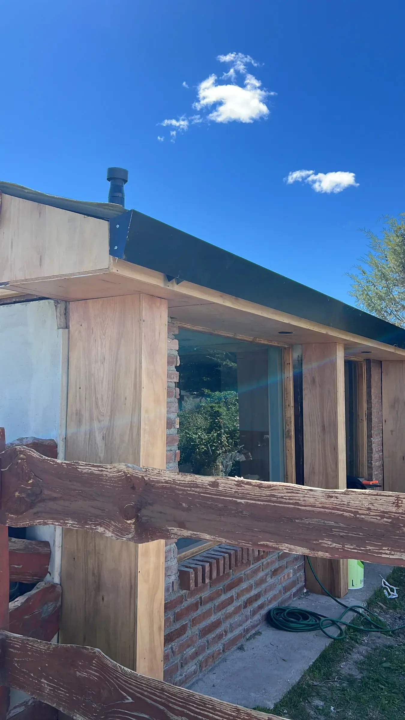 Surface Construcciones — reforma integral, fachada terminada en madera y ladrillo con ventanales