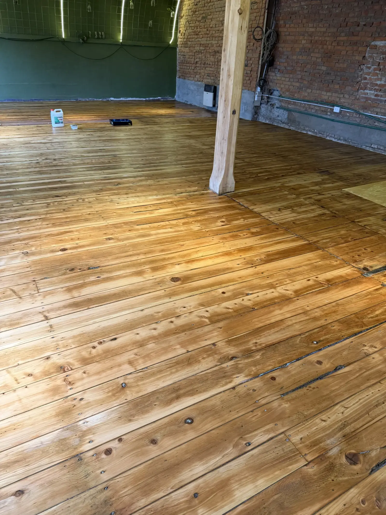 Surface Construcciones — remodelación de bar, piso de madera restaurado durante la obra