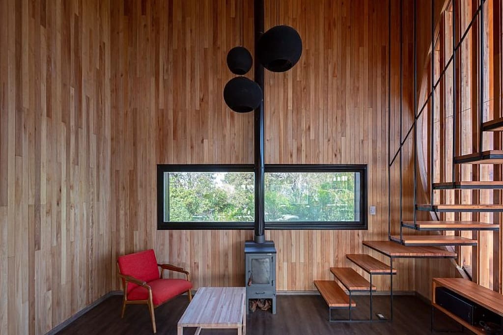 Surface Construcciones — Skate House (Trevelin, Patagonia), living terminado con estufa a leña