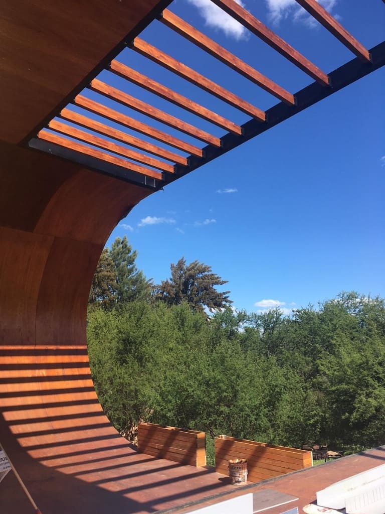 Surface Construcciones — Skate House (Trevelin, Patagonia), cubierta curva de madera abriéndose al cielo